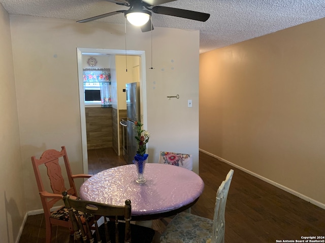 dining room with ceiling fan, a textured ceiling, and dark wood-type flooring