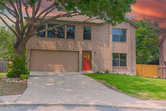 view of front of property featuring a garage and a lawn