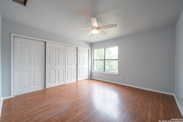 unfurnished bedroom featuring ceiling fan and dark hardwood / wood-style flooring