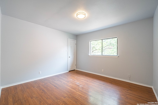 unfurnished room with wood-type flooring