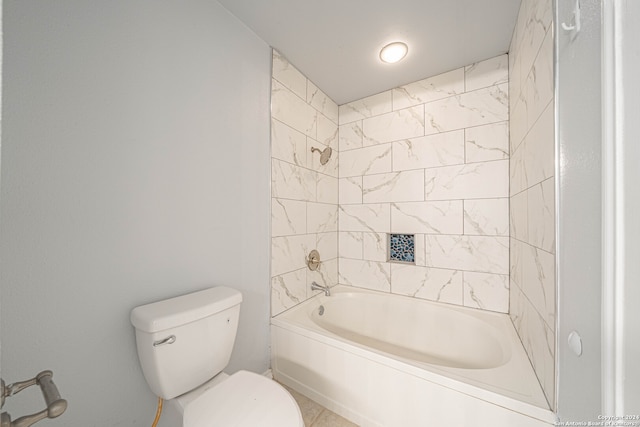 bathroom featuring toilet and tiled shower / bath