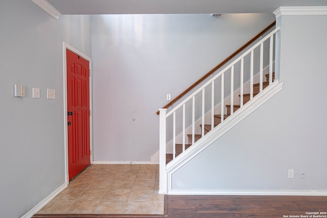 tiled foyer entrance featuring crown molding