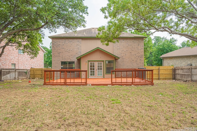 back of property with a lawn and a wooden deck