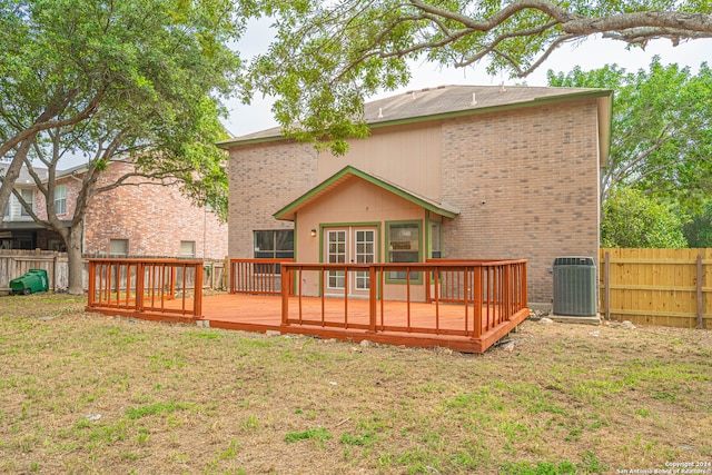 back of property with central AC, a yard, and a deck