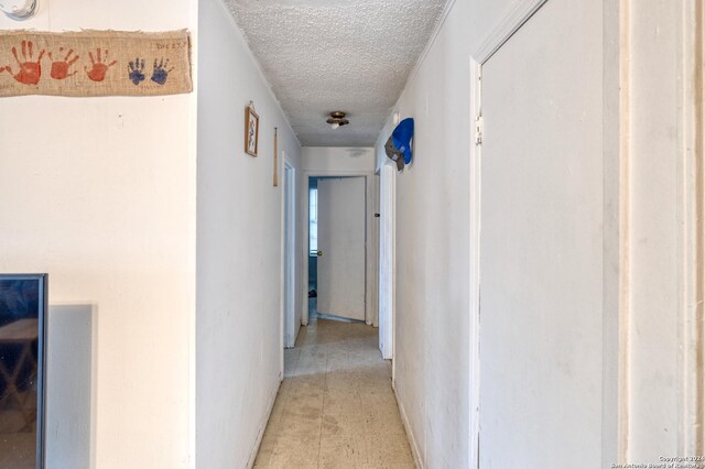 hall with a textured ceiling