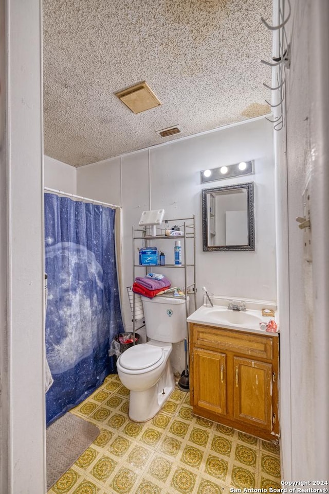 bathroom with vanity, a shower with shower curtain, a textured ceiling, and toilet