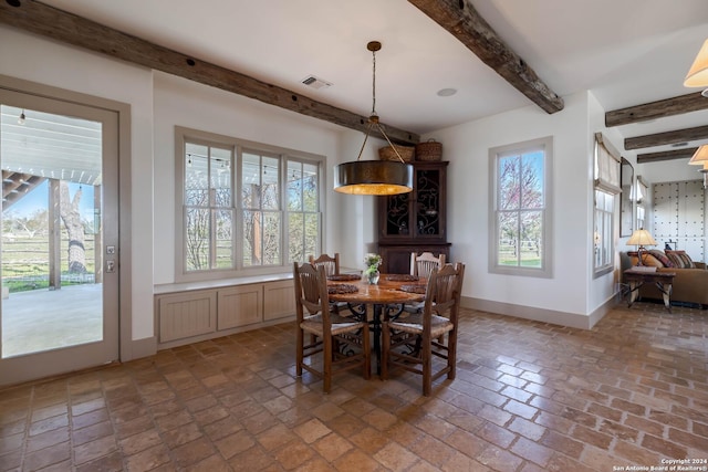 dining room with plenty of natural light and beam ceiling