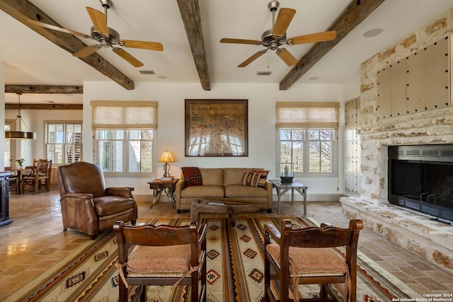 living room with a fireplace, ceiling fan, and beamed ceiling