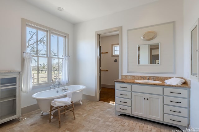 bathroom featuring a bathing tub, a wealth of natural light, and vanity