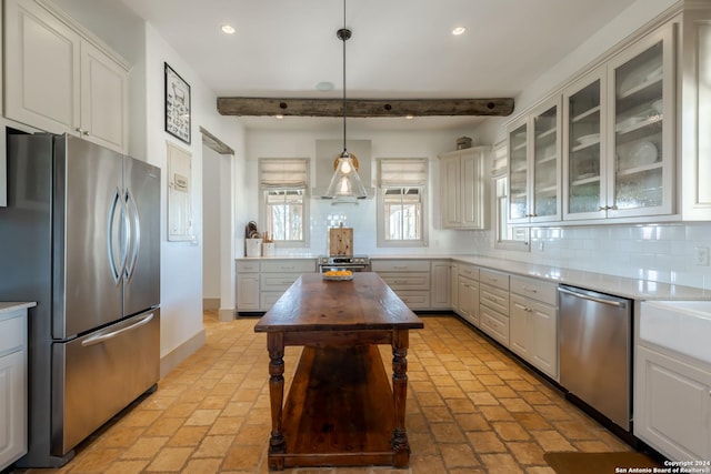 kitchen with decorative backsplash, appliances with stainless steel finishes, beam ceiling, decorative light fixtures, and white cabinetry