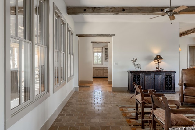 living room with ceiling fan and beamed ceiling