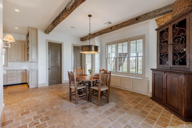 dining area with beam ceiling