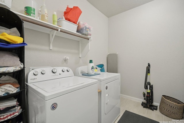 laundry area with laundry area, independent washer and dryer, and baseboards