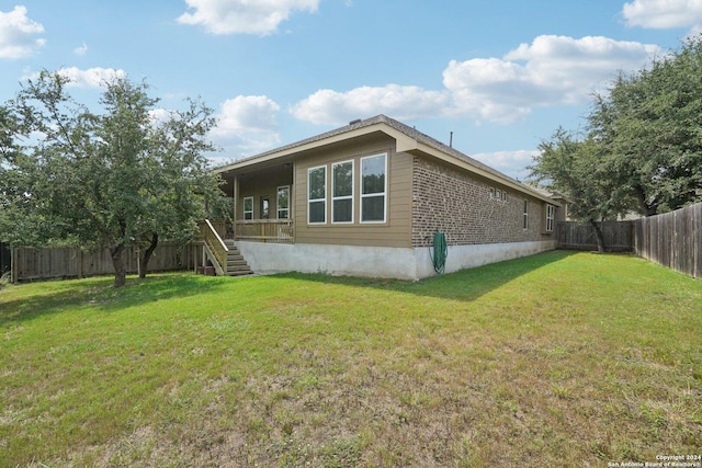 view of side of home featuring stairway, a lawn, and a fenced backyard