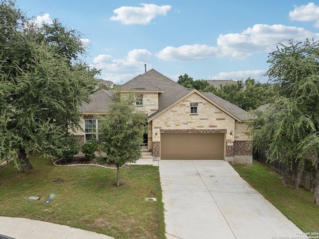 french country inspired facade featuring driveway, a front lawn, fence, roof with shingles, and an attached garage