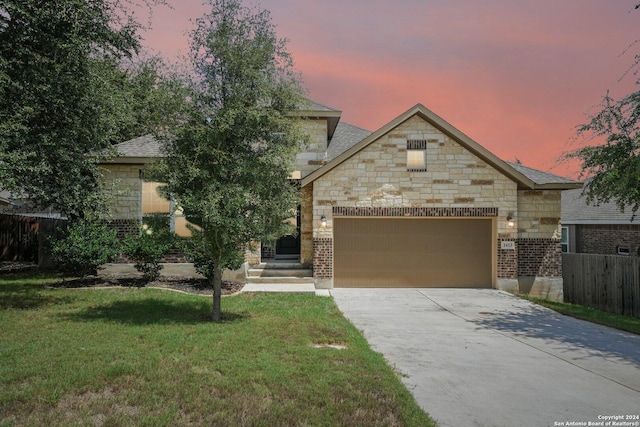 view of front of property with fence, concrete driveway, a front yard, a garage, and stone siding