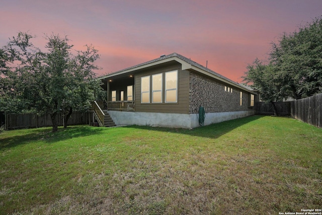 view of home's exterior with a yard, a fenced backyard, and stairway