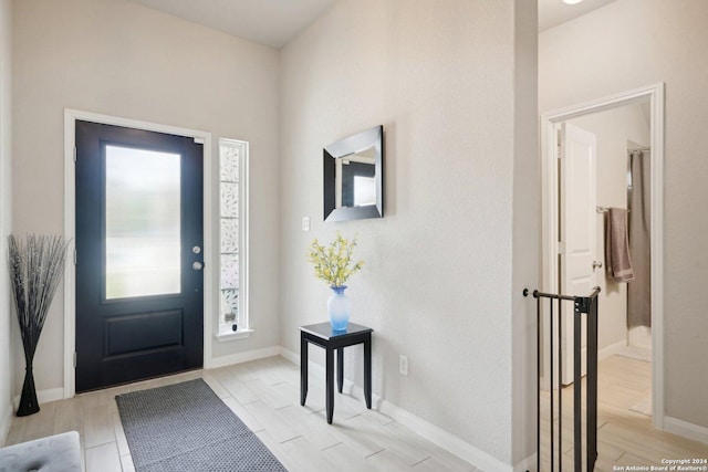 foyer entrance featuring baseboards and wood tiled floor