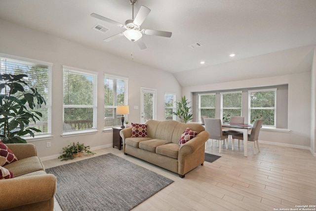 living area with visible vents, a healthy amount of sunlight, and lofted ceiling