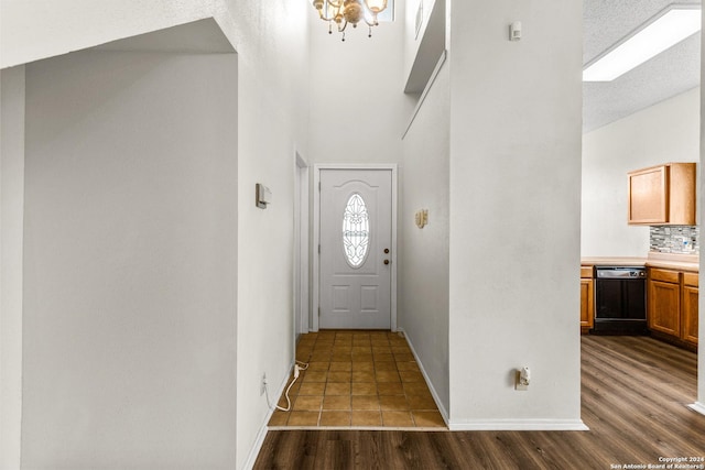 entryway featuring dark hardwood / wood-style flooring, a textured ceiling, and an inviting chandelier