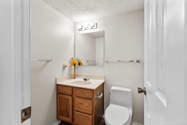 bathroom with vanity, a textured ceiling, and toilet