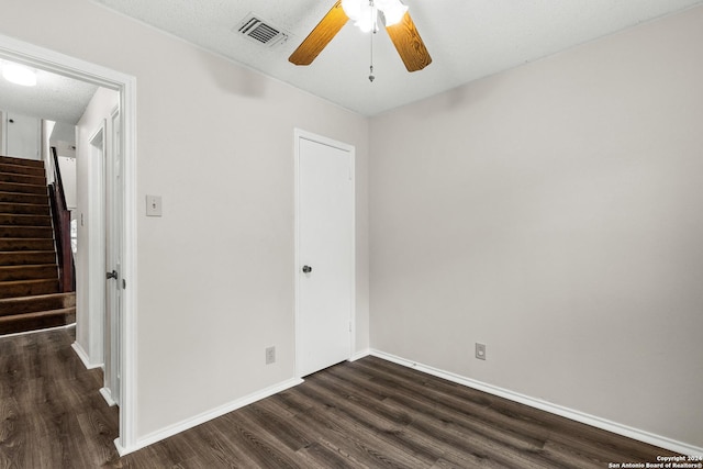 unfurnished room with dark hardwood / wood-style floors, ceiling fan, and a textured ceiling