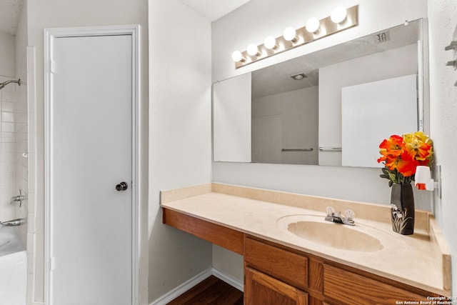 bathroom featuring hardwood / wood-style flooring, vanity, shower / tub combination, and a textured ceiling