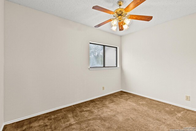 empty room featuring carpet, a textured ceiling, and ceiling fan