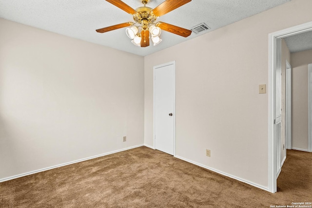 carpeted spare room featuring ceiling fan and a textured ceiling