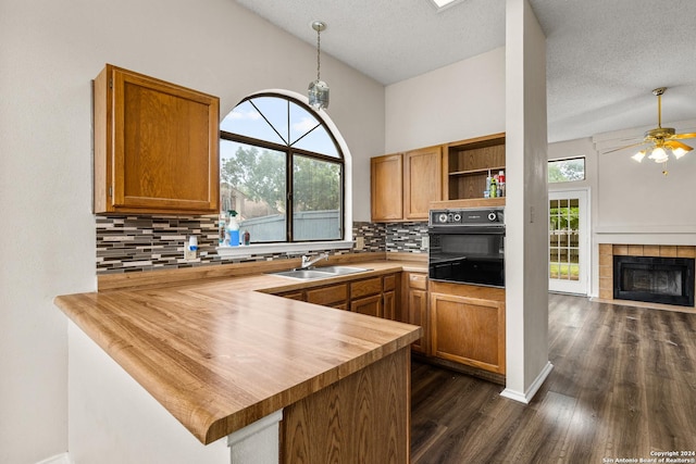 kitchen featuring kitchen peninsula, butcher block countertops, a wealth of natural light, and sink