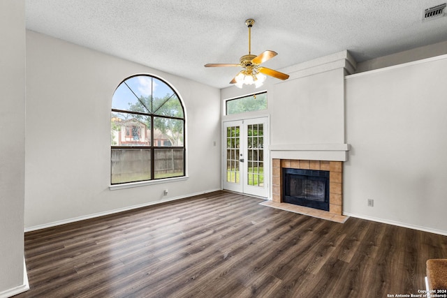 unfurnished living room featuring ceiling fan, dark hardwood / wood-style flooring, a textured ceiling, and french doors