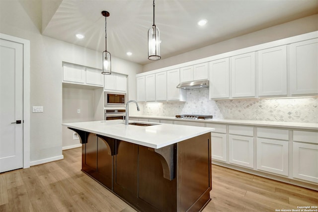 kitchen with white cabinets, light wood-type flooring, sink, and stainless steel appliances