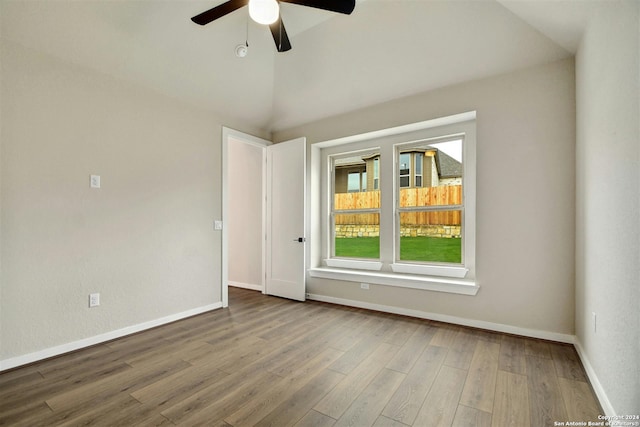 spare room with hardwood / wood-style flooring, vaulted ceiling, and ceiling fan