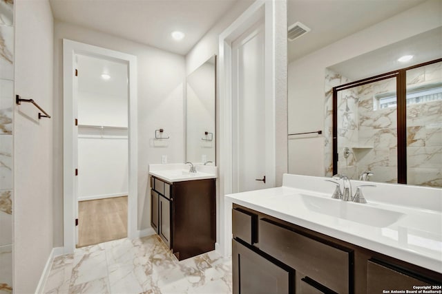 bathroom with a shower with door and vanity