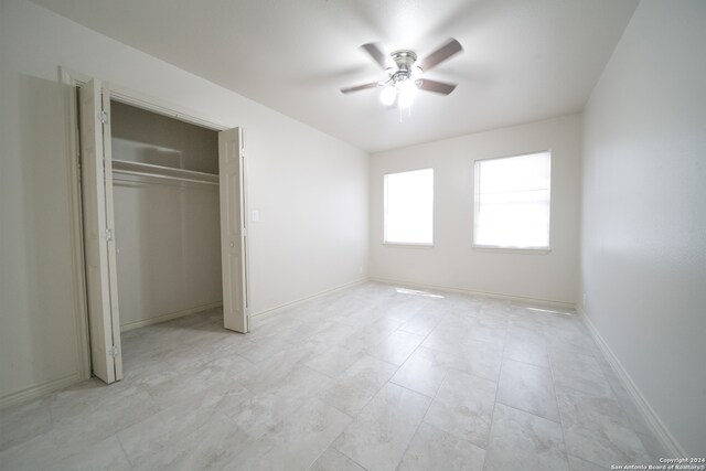 unfurnished bedroom featuring ceiling fan and a closet