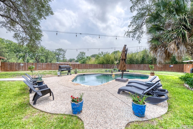 view of swimming pool with a grill, a patio area, and a lawn