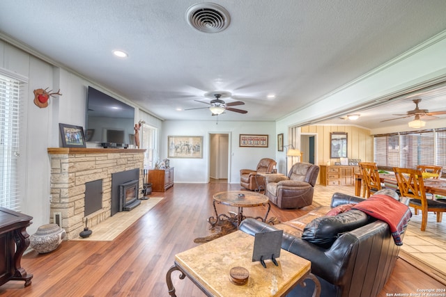 living room featuring wood-type flooring, crown molding, and a wealth of natural light