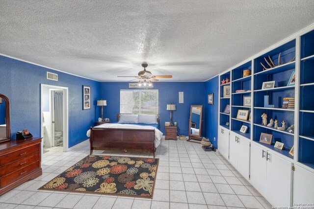 bedroom featuring ceiling fan, ensuite bathroom, light tile patterned floors, and a textured ceiling