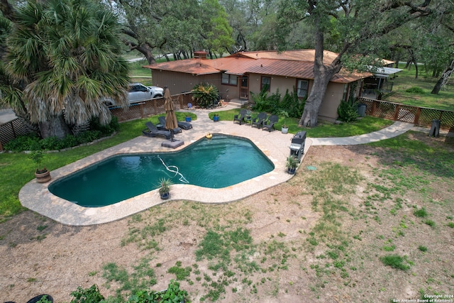 view of swimming pool with a lawn, sink, and a patio