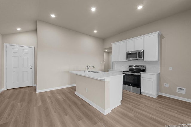 kitchen with sink, white cabinets, an island with sink, light hardwood / wood-style floors, and stainless steel appliances