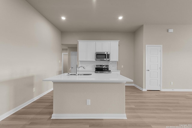 kitchen with white cabinets, an island with sink, appliances with stainless steel finishes, and decorative backsplash