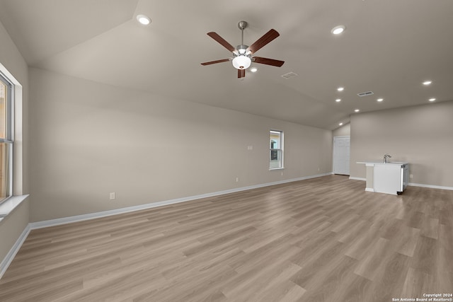 unfurnished living room with light hardwood / wood-style floors, ceiling fan, and lofted ceiling