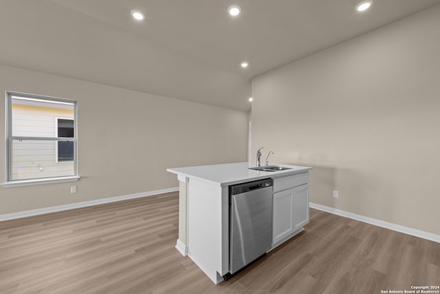 kitchen with light wood-type flooring, sink, dishwasher, white cabinetry, and an island with sink