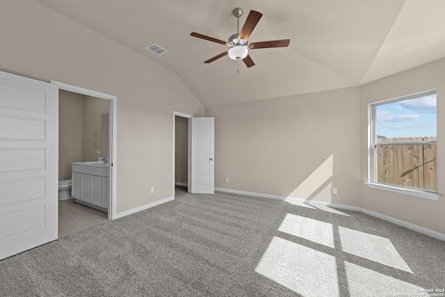 unfurnished bedroom with ensuite bath, light colored carpet, vaulted ceiling, ceiling fan, and sink