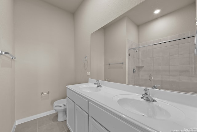 bathroom featuring tile patterned floors, vanity, toilet, and a shower with shower door