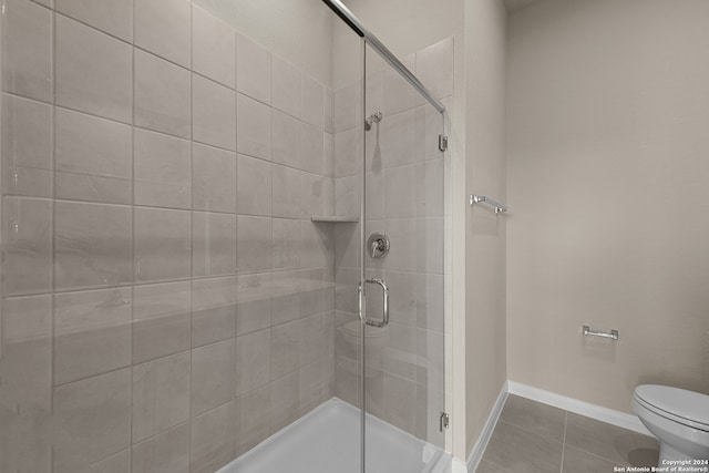 bathroom featuring tile patterned floors, toilet, and walk in shower