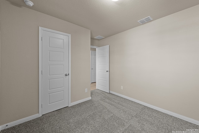 unfurnished bedroom with carpet and a textured ceiling