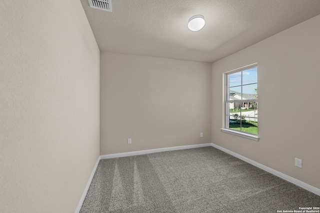 spare room featuring a textured ceiling and carpet floors