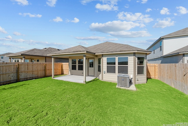 rear view of house with a lawn, a patio area, and central AC