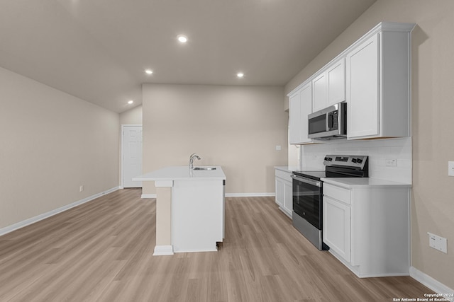 kitchen featuring appliances with stainless steel finishes, backsplash, a center island with sink, light hardwood / wood-style flooring, and white cabinets